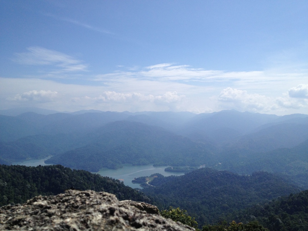 View of the north from the peak of Bukit Kutu. The prominent peaks of the Titiwangsa range are clearly visible. From right to left: Gunung Ulu Semangkok (highest peak on the right one-third of the picture), Gunung Gap (the small peak just to the right of a deep break in the mountain range. The break is where Gap is), Bukit Peninjau (the highest peak in Frasers Hill, just to the left of the Gap saddle), Pine Tree & Twin Peak (a double peak about one-third from the left of the picture - it's the highest mountain there) and Gunung Semangkok (the giant mountain on the far left, just about visible below the cloud). At the bottom of the picture is the Selangor river reservoir, the L-shaped road at the bottom bank of the lake is the KKB-Gap trunk road