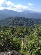 View of the east from the peak of Bukit Kutu. The chimney of the 1st bungalow can be seen below. In the background is Gunung Rajah